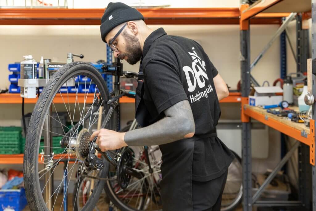 A participant at DENS bike project servicing a bike