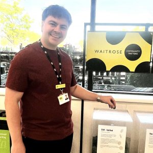 a man voting for DENS with a Waitrose token