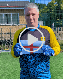 chris in his goalkeeper kit holding up an england flag