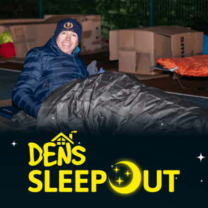 A man sat outside in a sleeping bag